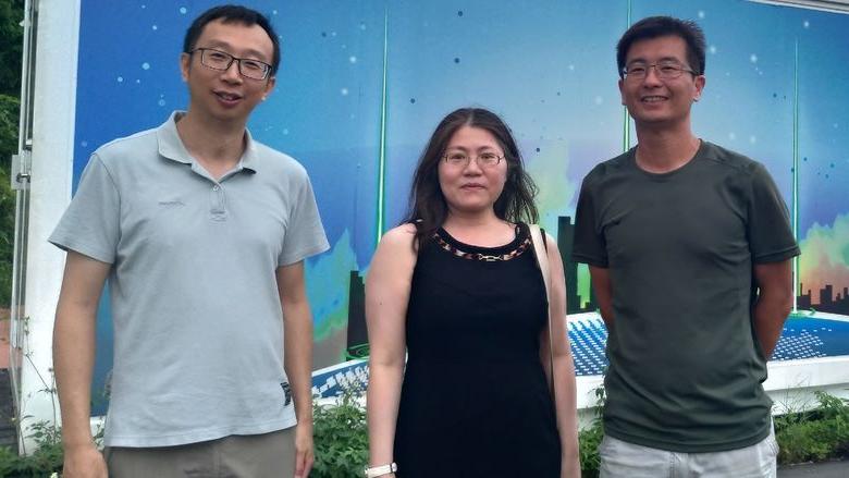 three people in front of lab facility in Taiwan